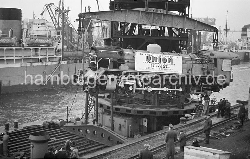 Verladung Dampf-Lokomotive Hafen Hamburg - Schwimmkran 1952 442_09 Verladung von fabrikneuen Dampflokomotiven im Hamburger Hafen; die in den Henschel-Werken gebauten Loks werden im Ellerholzhafen am Mnckebergkai mit einem Schwimmkran von den Gleisen gehoben und zum Frachter transportiert.