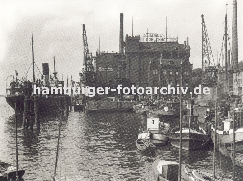 0954046 Blick auf den grossen Kohlespeicher am Hafen von Hamburg - Altona; grssere Schiffe und kleine Boote liegen am Kai oder den Dalben; im Vordergrund zwei Sport-Segelboote. Kaikran strecken ihre Ausleger in den Himmel.