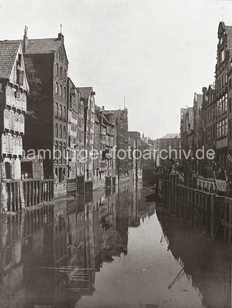 0118_3512_4 Blick auf den Hollndischen Brook - Handkarren stehen entlang der gepflasterten Strasse, mit kleinen Krnen kann die Ladung der Schuten an Land gebracht werden. An den Lagergebuden der Wasserseite des Fleets befinden sich Winden unter dem Giebel und einige auch auf Strassenhhe.  Die Wasserstraen der Fleete bildeten fr den Warentransport in Hamburg ein bedeutendes Verkehrsnetz. Die Huser der reichen Kaufleute – meist Wohn- und Lagerhaus zugleich – wurden mit der Rckfront zum Fleet und der Vorderfront zur Strae gebaut, oft beidseitig mit entsprechenden Hebevorrichtungen fr Lasten. Die Ladungen der Seeschiffe wurden zunchst auf kleinere Schuten umgeschlagen und zur Zwischenlagerung bzw. weiteren Verarbeitung ber die Fleete an den Bestimmungsort verbracht. Ab 1883 wurden die Wohnviertel auf den Elbinseln Kehrwieder und Wandrahm abgerissen, um die Speicherstadt zu errichten. Etwa 20 000 Menschen wurden zwangsumgesiedelt und ca. 1100 Huser zerstrt.