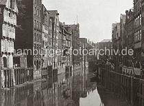 0118_3512_4 Blick auf den Hollndischen Brook - Handkarren stehen entlang der gepflasterten Strasse, mit kleinen Krnen kann die Ladung der Schuten an Land gebracht werden. An den Lagergebuden der Wasserseite des Fleets befinden sich Winden unter dem Giebel und einige auch auf Strassenhhe.  Die Wasserstraen der Fleete bildeten fr den Warentransport in Hamburg ein bedeutendes Verkehrsnetz. Die Huser der reichen Kaufleute – meist Wohn- und Lagerhaus zugleich – wurden mit der Rckfront zum Fleet und der Vorderfront zur Strae gebaut, oft beidseitig mit entsprechenden Hebevorrichtungen fr Lasten. Die Ladungen der Seeschiffe wurden zunchst auf kleinere Schuten umgeschlagen und zur Zwischenlagerung bzw. weiteren Verarbeitung ber die Fleete an den Bestimmungsort verbracht. Ab 1883 wurden die Wohnviertel auf den Elbinseln Kehrwieder und Wandrahm abgerissen, um die Speicherstadt zu errichten. Etwa 20 000 Menschen wurden zwangsumgesiedelt und ca. 1100 Huser zerstrt.