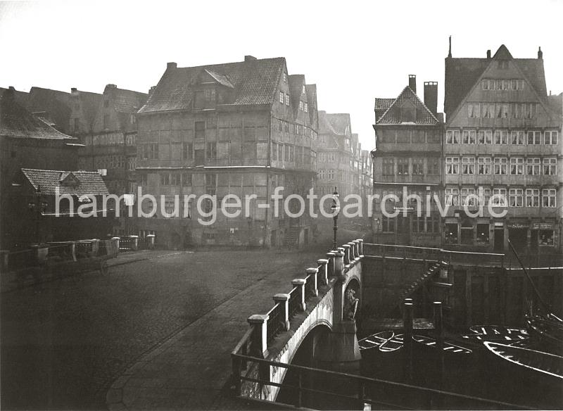 0128_030_20 Die steinerne Brooksbrcke fhrt ber das Fleet zum Kehrwieder - am Mittelpfeiler der Brcke steht eine Lwenskulptur mit dem Hamburger Wappen im Schild.  Am Anleger sind mehrere Holzboote festgemacht - eine Treppe fhrt zur gepflasterten Strasse. Die Wasserstraen der Fleete bildeten fr den Warentransport in Hamburg ein bedeutendes Verkehrsnetz. Die Huser der reichen Kaufleute – meist Wohn- und Lagerhaus zugleich – wurden mit der Rckfront zum Fleet und der Vorderfront zur Strae gebaut, oft beidseitig mit entsprechenden Hebevorrichtungen fr Lasten. Die Ladungen der Seeschiffe wurden zunchst auf kleinere umgeschlagen und zur Zwischenlagerung bzw. weiteren Verarbeitung ber die Fleete an den Bestimmungsort verbracht. Ab 1883 wurden die Wohnviertel auf den Elbinseln Kehrwieder und Wandrahm abgerissen, um die Speicherstadt zu errichten. Etwa 20 000 Menschen wurden zwangsumgesiedelt und ca. 1100 Huser zerstrt.