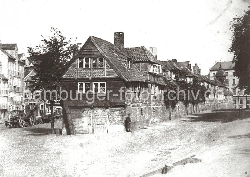 0129_030_133 Fachwerk-Wohnhuser in der Dienerreihe - die Gebude wurden fr die Ratsdiener errichtet; rechts im Hintergrund der Turm der ehemaligen St. Annen Kapelle. Links stehen leere Holzfuhrwerke am Strassenrand. Ab 1883 wurden die Wohnviertel auf den Elbinseln Kehrwieder und Wandrahm abgerissen, um die Speicherstadt zu errichten. Etwa 20 000 Menschen wurden zwangsumgesiedelt und ca. 1100 Huser zerstrt.