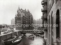 0149_17_1_28 Blick in das Wandrahmsfleet auf die Brcke der Hollndischen Reihe (Dienerreihe) - offene und abgedeckte Schuten liegen auf dem Wasser an den Kaimauern oder unter dem Lagergebude des Speicherblocks W. Auf der Strasse stehen Handkarren und Pferd + Wagen zum Weitertransport der Waren. Im Hintergrund sind die Gebude der Speicherblcke 0 und W zu erkennen.  Die Hamburger Speicherstadt wurde ab 1883 errichtet. Dabei wurden zunchst die ab dem 16. Jahrhundert auf den Elbinseln Kehrwieder und Wandrahm gewachsenen Wohnviertel abgerissen. Der Kehrwieder galt als Arbeiter- und Handwerkerviertel mit teilweise enger Gngeviertelbebauung, der Wandrahm war vor allem mit Kaufmanns- und Brgerhusern aus dem 17. und 18. Jahrhundert bebaut und insbesondere von hollndischen Einwanderern geprgt. Die Realisierung und Verwaltung der Speicherstadt wurde im Jahr 1885 durch die Hamburger Freihafen-Lagerhaus-Gesellschaft (HFLG) bernommen. Bis 1889 entstanden zwischen Kehrwiederspitze und Kannengieerort etwa 60 Prozent der Lagerflchen (Blcke A bis O). Im zweiten Bauabschnitt von 1891 bis 1897 wurden die Speicherblcke P, Q und R am St. Annenufer und Neuer Wandrahm errichtet. Im dritten Bauabschnitt von 1899 bis 1927, unterbrochen durch den Ersten Weltkrieg und die Inflationsjahre, wurde das Gebiet stlich der Strae Bei St. Annen fertig gestellt (Blcke S bis X). Das "Rathaus" der Speicherstadt, das Verwaltungsgebude der HHLA, wurde 1903 eingeweiht. Insgesamt entstanden 24 Speicherblcke mit rund 300.000 Quadratmeter Lagerflche.