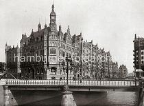 0150_17_1_29 Im Vordergrund die St. Annenbrcke ber das Hollndische Brooksfleet - eine Gaslaterne mit drei schmiedeeiserne Lampen steht in der Mitte der Brcke; darunter auf dem Brckenpfeiler eine Vogelfigur ( Schwan?) die das Wappenschild der Hansestadt hlt.  Am Hollndischen Brook liegt das grosse Verwaltungsgebude der Hamburger Freihafen-Lagerhaus-Gesellschaft HFLG, das mit seinen vielen neogotischen Giebeltrmen auch das Speicherstadtrathaus genannt wird. Dahinter schliesst der Speicherblock U an, der mit seiner Wasserseite am Wandrahmsfleet liegt. Rechts ein Ausschnitt des Blocks V. Die Hamburger Speicherstadt wurde ab 1883 errichtet. Dabei wurden zunchst die ab dem 16. Jahrhundert auf den Elbinseln Kehrwieder und Wandrahm gewachsenen Wohnviertel abgerissen. Der Kehrwieder galt als Arbeiter- und Handwerkerviertel mit teilweise enger Gngeviertelbebauung, der Wandrahm war vor allem mit Kaufmanns- und Brgerhusern aus dem 17. und 18. Jahrhundert bebaut und insbesondere von hollndischen Einwanderern geprgt. Die Realisierung und Verwaltung der Speicherstadt wurde im Jahr 1885 durch die Hamburger Freihafen-Lagerhaus-Gesellschaft (HFLG) bernommen. Bis 1889 entstanden zwischen Kehrwiederspitze und Kannengieerort etwa 60 Prozent der Lagerflchen (Blcke A bis O). Im zweiten Bauabschnitt von 1891 bis 1897 wurden die Speicherblcke P, Q und R am St. Annenufer und Neuer Wandrahm errichtet. Im dritten Bauabschnitt von 1899 bis 1927, unterbrochen durch den Ersten Weltkrieg und die Inflationsjahre, wurde das Gebiet stlich der Strae Bei St. Annen fertig gestellt (Blcke S bis X). Das "Rathaus" der Speicherstadt, das Verwaltungsgebude der jetzigen HHLA, wurde 1903 eingeweiht. Insgesamt entstanden 24 Speicherblcke mit rund 300.000 Quadratmeter Lagerflche.