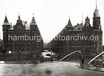 0164_090_1 Blick von der Kehrwiederspitze auf die Wilhelminenbrcke und das Kehrwiederfleet - Lastkhne liegen unter den Winden der Lagerbden. Links der Speicherblock A und rechts der Block J; eine weit sichtbare Uhr ist im Giebel des Lagergebudes angebracht - links im Hintergrund der Turm der St. Katharinenkirche. Die Hamburger Speicherstadt wurde ab 1883 errichtet.  Die Realisierung und Verwaltung der Speicherstadt wurde im Jahr 1885 durch die Hamburger Freihafen-Lagerhaus-Gesellschaft (HFLG) bernommen. Bis 1889 entstanden zwischen Kehrwiederspitze und Kannengieerort etwa 60 Prozent der Lagerflchen (Blcke A bis O). Im zweiten Bauabschnitt von 1891 bis 1897 wurden die Speicherblcke P, Q und R am St. Annenufer und Neuer Wandrahm errichtet. Im dritten Bauabschnitt von 1899 bis 1927, unterbrochen durch den Ersten Weltkrieg und die Inflationsjahre, wurde das Gebiet stlich der Strae Bei St. Annen fertig gestellt (Blcke S bis X). Das "Rathaus" der Speicherstadt, das Verwaltungsgebude der HHLA, wurde 1903 eingeweiht. Insgesamt entstanden 24 Speicherblcke mit rund 300.000 Quadratmeter Lagerflche.