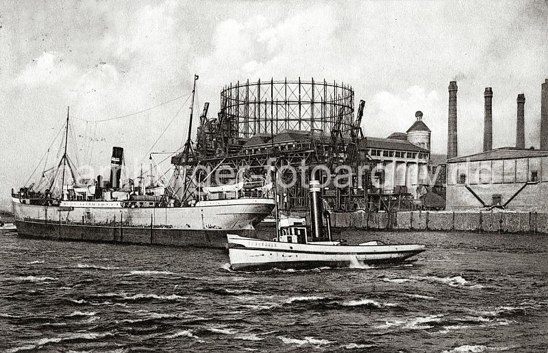 0174_237_76_2 Ein Schlepper mit hohem Schornstein berquert die Elbe beim Gaswerk Grasbrook - ein Frachtschiff hat im Strom an den Dalben fest gemacht. Im Hintergrund die Krananlagen am Kai des Hamburger Gaswerks auf dem Grasbrook.  Die Gaswerke wurden dort 1844 als Privatgesellschaft gegrndet, 1845 bei einer Sturmflut zerstrt und 1846 wieder aufgebaut. 1874 ging die Anlage in den Besitz der Stadt ber. In den vier Gasbehltern  knnen insgesamt 73 000 cbm Gas gespeichert werden. Das grte Gasometer hat einen Durchmesser von 56m - es kann 50 000 cbm speichern. Die Kohle wird von Seeschiffen gebracht, die direkt am Kai des Gaswerks mit einem hydraulischen Kran entladen werden. In neun Kohlenschuppen knnen ca. 30 000 t Kohle auf dem Gelnde der Gasanstalt Grasbrook gelagert werden.