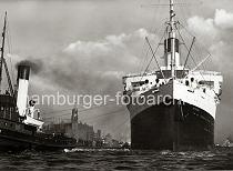 0183_224_84 Das Passagierschiff Cap Arcona luft aus dem Hamburger Hafen aus - Hafenschlepper untersttzen das ca. 200m lange und 25m breiten Passagierdampfer bei der Ausfahrt. Das Dampfschiff hat eine Besatzung von 630 Personen und kann ursprnglich 1315 Passagiere an Bord nehmen. Zwischen den Trossen der Schlepper ist das Speichergebude und der Uhrturm des Kaispeichers A am Kaiserhft zu sehen; rechts davon die Einfahrt zum Grasbrookhafen.