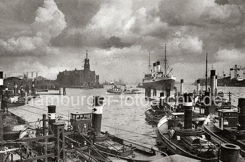 0184_224_81a Hafenschlepper liegen an ihren Liegepltzen bei den Vorsetzen; eine Hafenfhre hat die Elbe gekreuzt und fhrt Richtung Sandtor-Anleger. An den Dalben auf Hhe des Kaisspeichers liegt ein Passagierschiff im Strom.