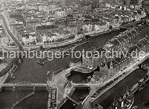 0186_237_73_2 Blick auf die Hamburger Speicherstadt und den Binnenhafen; links im Vordergrund die Niederbaumbrcke und die Hochbahnhaltestelle BAUMWALL. Vorne rechts die Kaischuppen am Sandtorkai, ein Dampfer liegt am Kai.