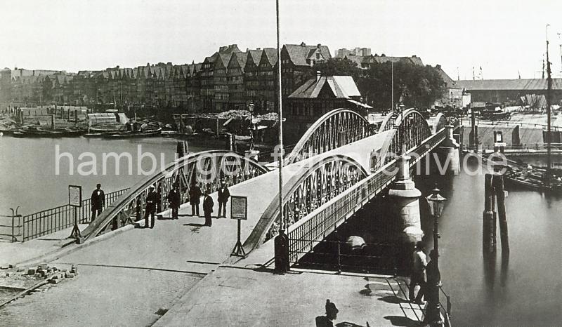 0192 Niederbaumbrcke vom Baumwall zum Kehrwieder; rechts im Hintergrund einer der Kaischuppen am Sandtorhafen. Links die Wohn- und Gewerbegebude am Kehrwieder; Schuten und Arbeitsschiffe liegen im Wasser.