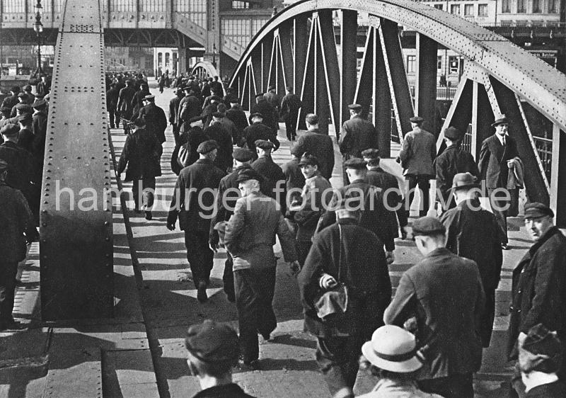 0194_3506_21 Niederbaumbrcke ber den Zollkanal; Hafenarbeiter gehen nach Schichtende nach Hause - im Hintergrund das Gebude der Hochbahnhaltestelle Baumwall.