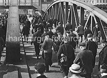 0194_3506_21 Niederbaumbrcke ber den Zollkanal; Hafenarbeiter gehen nach Schichtende nach Hause - im Hintergrund das Gebude der Hochbahnhaltestelle Baumwall.