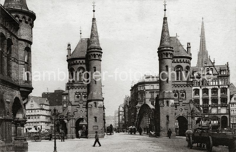 0203_222_04b Zollstation mit Giebeltrmen auf der Freihafenseite der Brooksbrcke; Pferdefuhrwerke passieren mit ihrer Ladung die Brcke, Fussgnger gehen durch den schmalen Torweg - Schilder weisen auf die Zollgrenze hin. Im Hintergrund Geschftshuser Bei Den Mhren und der neogotische Turm der St. Nikolai Kirche.