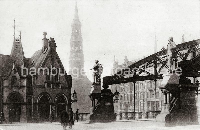 0207_222_0a Die Skulpturen der Entdecker Ferdinand Magellan (lks.) und James Cook stehen auf der Freihafenseite der Kornhausbrcke. Zollbeamte mit Dienstmtze und langen Mnteln befinden sich vor dem Zollgebude an der Zollgrenze des Freihafengelndes. Im Hintergrund auf der anderen Seite des Zollkanals das Zippelhaus mit der Dackskulptur des Fuhrmannes, links der Kirchturm der St. Katharinenkirche. 