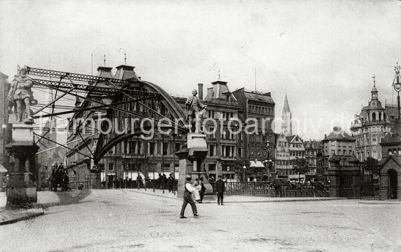 0208_113a Blick vom Freihafengelnde auf die Kornhausbrcke mit den beiden Portalskulpturen James Cook und Ferdinand Magellan. Auf der Brcke fhrt ein Pferdefuhrwerk mit einem Kutscher, dahinter die Brandstwiete und der Kirchturm der St. Petrikirche. Rechts der Dovenhof am Dovenfleet und im Hintergrund der Turm der St. Jacobikirche.