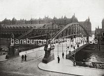 0209_017_1_33 Portalskulpturen der Kornhausbrcke am Dovenfleet/Zippelhaus; rechts die Figur von Vasco da Gama, links die Skulptur von Christoph Columbus - ein Pferdefuhrwerk berquert die Brcke ber den Zollkanal. Im Hintergrund der Speicherblock T und das Verwaltungsgebude der Hamburger Freihafen-Lagerhaus-Gesellschaft (HFLG) an der St. Annenbrcke.