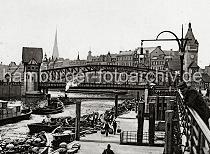 0221_222_01a Schiffsponton am Gemsemarkt bei den Deichtorhallen - Schuten mit ihrer Ladung haben am Anleger fest gemacht. Markthndler tragen ihre Ware in Kiepen zum Markt. Ein Schlepper zieht einen mit Kisten beladenen Kahn aus dem Oberhafen Richtung Zollkanal; ein weiterer Hafenschlepper fhrt gerade unter der Wandrahmsbrcke. Im Hintergrund die mehrstckigen Huser am Dovenfleet.