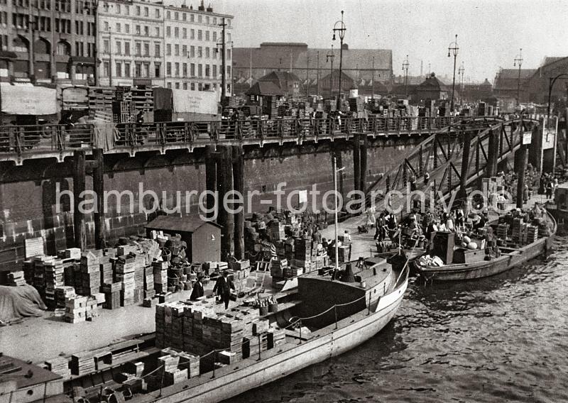 0223_3506_68 Khne liegen am Ponton des Deichtormarkts und werden entladen. Hoch sind die Gemsekisten und Krbe auf den Lastkhnen und an Land gestapelt. Mit Handkarren und Stechkarren wird die Ladung die Wassertreppe hinauf zum Markt gebracht. 