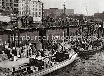 0223_3506_68 Khne liegen am Ponton des Deichtormarkts im Oberhafen und werden entladen. Hoch sind die Gemsekisten und Krbe auf den Lastkhnen und an Land gestapelt. Mit Handkarren und Stechkarren wird die Ladung die Wassertreppe hinauf zum Markt gebracht.