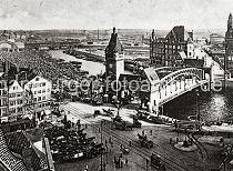 0225_237_81_1 Eingespannte Zugpferde stehen mit ihren Fuhrwerken auf dem Messberg, die Kutscher warten auf der Strasse auf eine Fuhre. Auf der Wandrahmsbrcke ber dem Zollkanal warten die Pferdefuhrwerke; die Marktflche auf dem Gemsemarkt ist mit Hndlern und Kunden dicht gefllt. An den Kais des Oberhafen liegen die Schuten und Lastkhne in mehreren Reihen. Im Hintergrund die Oberhafenbrcke und die Gemsehalle.