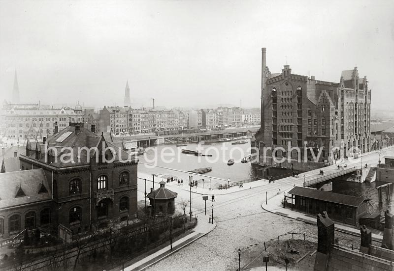 0236_39808 Kaispeicher B an der Meyerstrasse zwischen Brooktorhafen und Magdeburger Hafen. Der Silospeicher wurde  1879 unter der Leitung der Architekten Hanssen + Meerwein errichtet und 1884 zu einem Bodenspeicher mit 11020 m Lagerflche umgebaut. 1890 bernahm das Lagergebude die Hamburger Freihafen-Lagerhaus-Gesellschaft (HFLG), so dass sich smtliche Speicher im Freihafen von der HFLG betrieben wurden.Links ein Gebude des 1886 errichteten Amtes fr Strom und Hafenbau. Schienen fhren ber die Meyerstrassen-Drehbrcke - im Hintergrund die Zollpontons im Brooktorhafen sowie die Durchfahrt in den Fleet. Dahinter das Hauptzollamt mit dem Kuppelgiebel und Wohn / Geschftshuser am Brooktorkai. Offene und geschlossene Gterwagen stehen auf den Schienen der Kaianlage. 