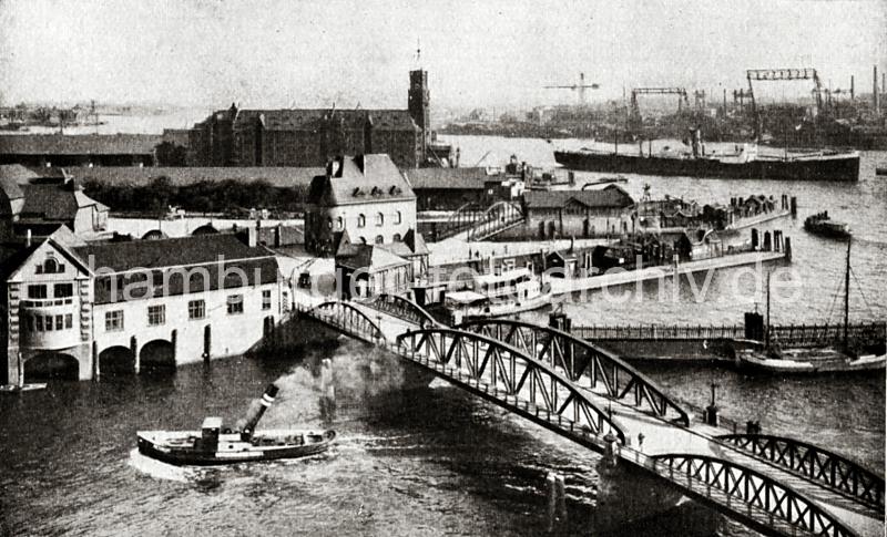 0238_84_141 Ein Schlepper hat gerade die Niederbaumbrcke unterfahren - der herunter geklappte Schornstein wird wieder aufgerichtet. Hinter der Brcke der Zollzaun, der das Freihafengebiet abgrenzt und der Fhranleger am Kehrwieder. Das dahinterliegende Sandtorhft wird von einer Hafenbarkasse angefahren. In der Bildmitte das Gebude der Polizeiwache auf dem Kehrwieder, Kaischuppen am Sandtorkai und das massive Ziegelgebude des Kaispeichers A an der Norderelbe.