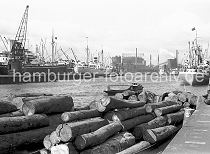 177_01 Blick ber den Baakenhafen 1956; am Versmannkai liegen Schuten mit Baumstmmen beladen - ein Frachter hat an den Eisenpollern festgemacht. In der Mitte des Hafenbeckens liegen weitere Frachtschiffe an Dalben - ein Schwimmkran lscht die Ladung; im Hintergrund der Gasometer vom Gaswerk Grasbrook.