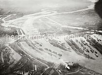 239_342_04 Im Vordergrund der qualmende Schlot der Gaswerke auf den Grasbrook - Blick auf die Hafenbecken vom Baakenhafen, Oderhafen und Segelschiffhafen; dann der Mggenburger Zollhafen und der Mggenburger Kanal. Lks. hinter den Elbbrcken der Entenwerder Zollhafen und die Einfahrt zur Billwerder Bucht und dem Holzhafen mit den Filterbecken auf der Elbinsel Kaltehofe.