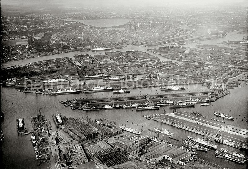 historische Hafenfotos der HHLA - Luftbild vom Hafen Hamburg - Hafenbecken, Elbe und Hamburger Innenstadt; ca. 1930, alte Hamburg Bilder auf Fotoleinwand Poster als Geschenk fr Bro und Wohnung.</title> 241_R_188_01 Der Hamburger Hafen aus der Luft - im Vordergrund links der Vulkanhafen; rechts der Rohafen, dahinter der Ellerholzhafen und ein Teil des Oderhafens. Im Bildzentrum das Hafenbecken des Kaiser Wilhelm Hafens und der Kuhwerder Hafen. In der oberen rechten Bildmitte mndet der Reiherstieg  in die Elbe. Im Hintergrund die Hamburger Auenalster.