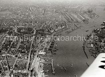 245_0333 historisches Luftaufnahme von Hamburg und den St. Pauli Landungsbrcken. In der linken Bildhlfte dei St. Michaeliskirche, rechts der Zollkanal an der Speicherstadt und der Sandtorhafen / Grasbrookhafen. Dahinter das Gasometer der Gaswerke auf dem Grasbrook und das Hafenbecken des Baakenhafens - ganz rechts oben die Elbbrcken ber die Norderelbe. 