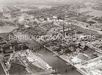 257_1425 Mehrere Brcken fhren ber den Mggenburger Kanal zum Betriebsgelnde der Norddeutschen Affinerie auf der Peute in Hamburg Veddel. Hinter den qualmende Schloten liegen Schuten und Binnenschiffe im Hovekanal und im Peute Hafen. Im Hintergrund re. die Elbbrcken und der Billehafen; lks. der Mggenburger Zollhafen, dahinter der Moldauhafen und Segelschiffhafen.