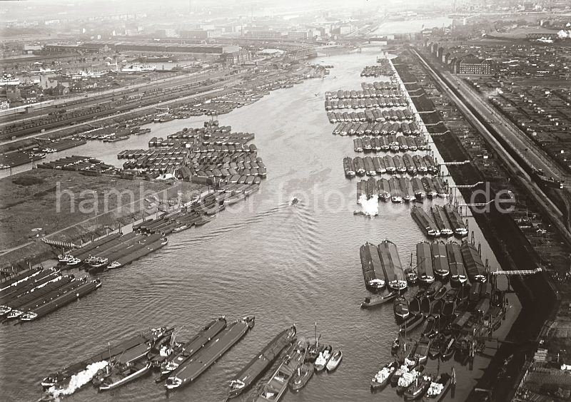 Luftaufnahme Spreehafen Hamburg Veddel / Freihafen; ca. 1931. Historische Hamburg Bilder,  Kunstdrucke auf Fotoleinwand / Keilrahme + Poster als Geschenk.</title> 258_R_188_20 Am Berliner Ufer des Spreehafens liegen die Binnenschiffe neun Reihen tief - Wassertreppen, die sich mit dem Tidenhub bewegen fhren hinunter zu den Liegepltzen. Auch am Spandauer Ufer und dem Niedernfelder Ufer des Veddel Kanals haben sehr viele Schuten und Binnenschiffe fest gemacht. Rechts im Hintergrund der Mggenburger Zollhafen und die Kirche und Gebude der Auswandererhallen auf der Veddel.