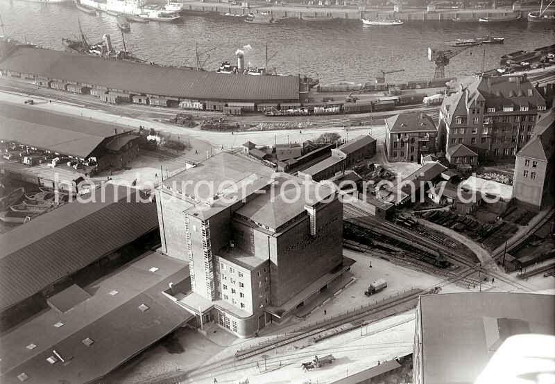 Luftaufnahme Herings-Khlhaus Hbenerkai, Grasbrookhafen; ca. 1930  279_0822 Blick auf das Heringskhlhaus am Hbenerkai des Grasbrookhafens; die Architektur des Gebudes wurde vom Hamburger Oberbaudirektor Fritz Schumacher entworfen. Rechts die Verwaltungsbauten des Amtes fr Strom- und Hafenbau. Dahinter die Kaianlagen und Lagerschuppen am Kaiser Kai des Sandtor Hafens.