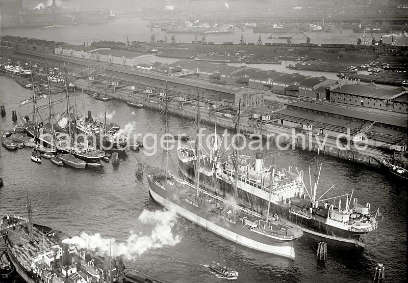 Luftbild vom Segelschiffhafen - Grosegler Pamir + Parma; ca. 1930 288_0012 An den Dalben im Segelschiffhafen die beiden Frachtsegler Pamir (lks.) und Parma - die Ladung der Viermastbark Pamir wird gerade gelscht - Schuten liegen lngsseits des Segelschiffs. Hinter den Lagerschuppen am Asia Kai Binnenschiffe und Schuten am Prager Ufer vom Moldauhafen; dahinter der Holthusen Kai und am gegenber liegenden Ufer der Norderelbe der Kirchenpauer Kai.  