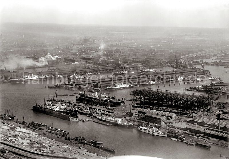 Flugbild Hafen Hamburg -  Vulkanhafen, Howaldtswerft - Ellerholzhafen; ca. 1930 - 291_0257 Im Vordergrund der Vulkanhafen und Schwimmdocks der Howaldtswerft; dahinter der liegen Frachtschiffe am Mnckebergkai des Ellerholzhafens. Am oberen rechten Bildrand die Ellerholzschleuse und lks davon der Kaiser- Wilhelm- Hafen.