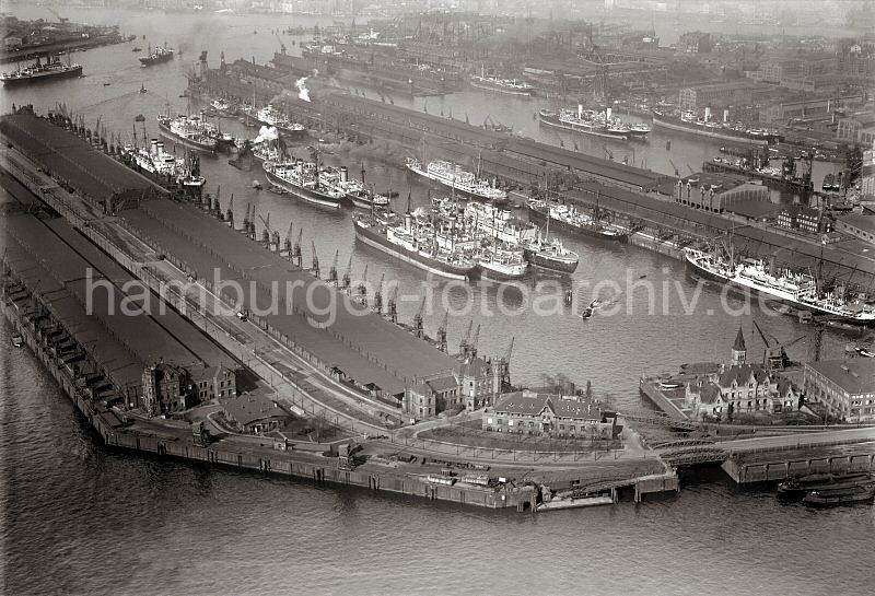 Flugbild Hafen Hamburg -  Kaiser Wilhelm Hafen, Kuhwrder Hafen; ca. 1931 - 292_3832 Luftfotografie vom Kaiser - Wilhelm - Hafen; lks. der Kronprinzenkai und rechts der Auguste Victoria Kai. Im Vordergrund am Reiherkai ein Verwaltungsgebude mit Giebelturm und die Durchfahrt zum Ellerholzhafen und dem Kohlenkai. Im Hintergrund der Kuhwerder Hafen mit einem Schwimmdock der Werft Blohm & Voss; lks. davon der Vorhafen.