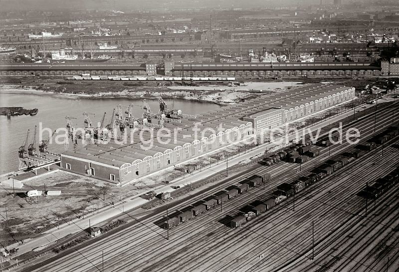 Luftfotografie Hafen Hamburg - Sd West Hafen;  Winkhukkai, Lagerschuppen 59; ca. 1932 295_3277 Luftfoto vom Windhukkai des Sd - West - Hafens,  dem Lagerschuppen 59  mit den Tonnengewlben am Veddeler Damm und den Gleisanlagen des Gterbahnhofs Hamburg Sd - der Togo Kai ist noch nicht befestigt. Dahinter stehen Gterwaggons auf den Gleisen am Afrika Kai des Asia Hafens.