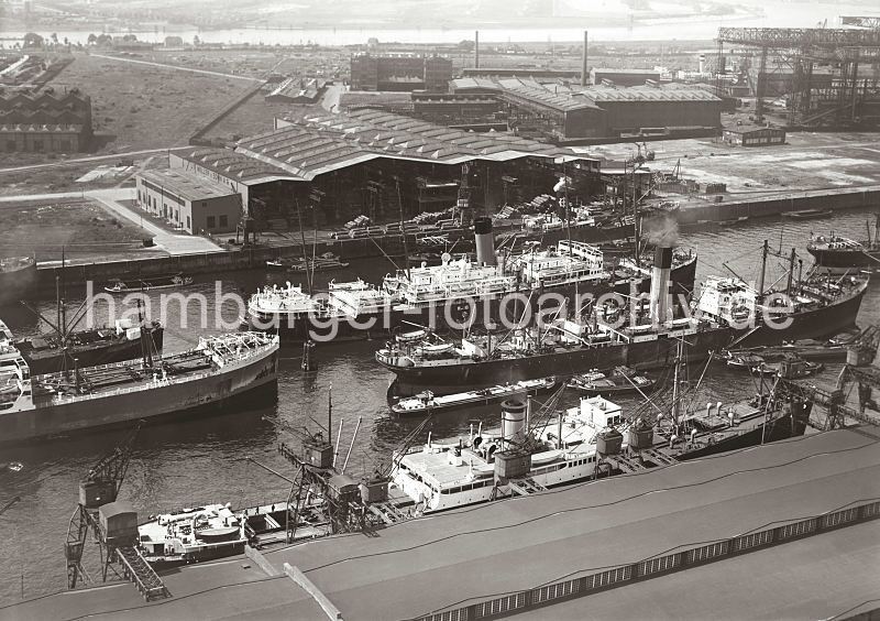 Hamburgensien als Kunstdruck, Fotoposter / Fotoleinwand - GEschenk zum Geburtstag, Weihnachten, Jubilaeum. Luftfotos vom Hafen der Hansestadt Hamburg - Frachter im Rohafen; ca. 1932. 298_R_188_19 Luftfoto vom Rosshafen im Hamburger Hafen; Frachtschiffe liegen an den Dalben. Die Ladung eines der Frachter wird ber Binnenschiffe und Khne, die lngseits fest gemacht haben gelscht. Links im Hintergrund Helgen der Howaldtswerft und im Hintergrund der Khlbrand. Lngsseits des Ufers sind Schrebergarten Kolonien, Felder und ein Badestrand zu erkennen.