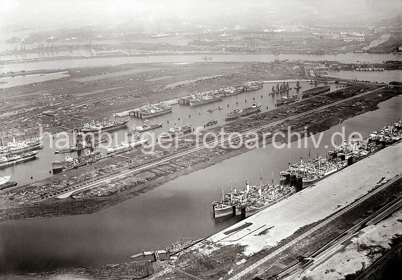 Hamburgensien als Kunstdruck, Fotoposter / Fotoleinwand - GEschenk zum Geburtstag, Weihnachten, Jubilaeum. Luftbilder vom Hafen der Hansestadt Hamburg - Waltershofer + Griesenwrder Hafen; ca. 1931. 299_0149 Luftfotografie vom Walteshofer Hafen und dem Griesenwerder Hafen; die Kaianlagen sind noch nicht fertig gestellt. Wegen der Wirtschaftskrise stillgelegte Frachtschiffe / Auflieger liegen in den beiden Hfen. Das Gelnde an den Ufern der Hafenbecken wird von Kleingrtnern genutzt, die dort ihre Schrebergarten Parzellen betreiben. Rechts hinter dem Waltershofer Hafen der Rugenberger Hafen und die Rugenberger Schleuse; lks. am Ufer des Khlbrands der Anleger der Khlbrandfhre - auf der gegenber liegenden Seite die Mndung des Rokanals.