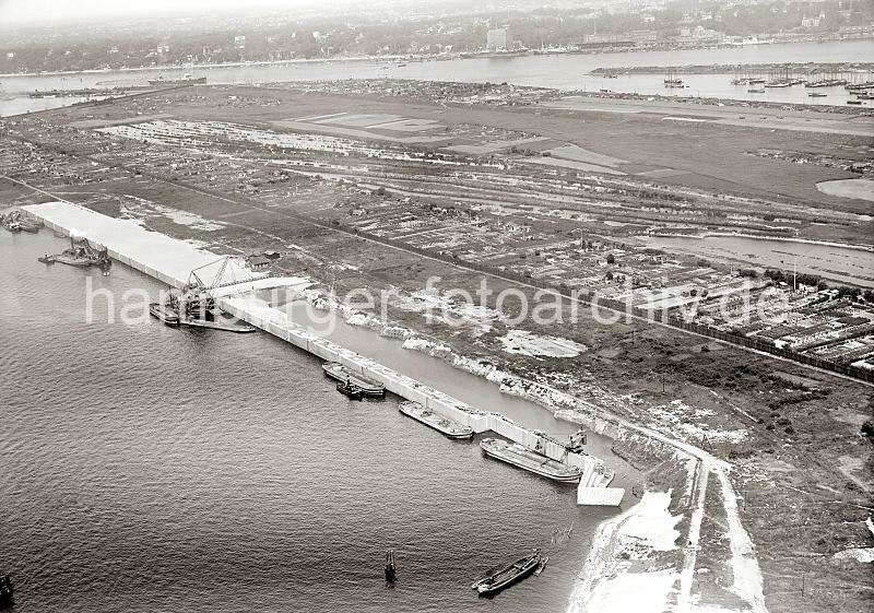 alte Hafenbilder als Kunstdruck und auf Fotoleinwand - Geschenk zum Geburtstag, Weihnachten, Jubilaeum. Luftfotografien Hafen Hamburg - Baustelle Waltershofer Hafen Burchardkai; ca. 1931. 301_0481 Luftbild von der Baustelle im Waltershofer Hafen; die Kaianlage des Burchardkais ist halb fertig gestellt. Arbeitsschuten liegen an der Spundwand, ein schwimmendes Frderband bringt den Sand von den Schuten zum Verfllen auf den Kai - ein Kettenbagger baggert das Hafenbecken auf die notwendige Tiefe aus. In der Mitte der Landzunge ist das Land in Schrebergartenparzellen aufgeteilt. Auf der gegenber liegenden Seite des Elbufers ist das Khlhaus in Neumhlen / Altona zu erkennen. Auf der rechten mittleren Bildseite wird gerade Heu geerntet - hoch beladene Heuwagen mit Pferden bespannt fahren die Ernte ein - dahinter liegen Fischkutter im Maakenwrder Hafen.