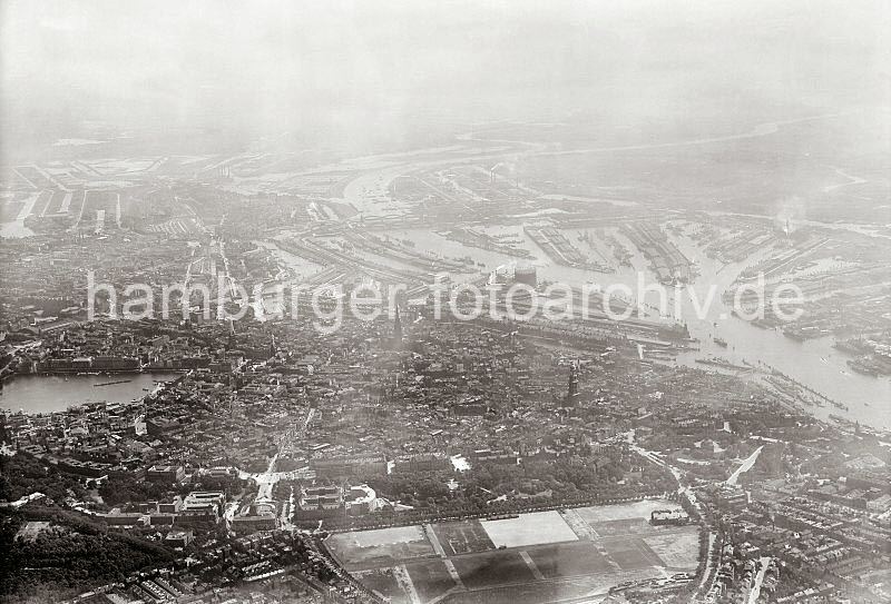 Historische Hafenfotos aus dem Bildarchiv der Hamburger Hafen und Logistik AG (HHLA)- Luftbilder von Hamburg - Hamburger Innenstadt + Elbe, Hafen; ca. 1931. 303_0595 Luftaufnahme von Hamburg; im Vordergrund die freie Flche des Heiligengeistfeld; re. darber der Kirchturm des St. Michaeliskirche, lks. die Binnenalster. Im Bildzentrum der Sandtor- und der Grasbrookhafen, sowie der Baakenhafen; auf dem gegenber liegenden Elbufer u.a. die Hafenbecken vom Moldau Hafen, dem Segelschiffhafen und dem Hansahafen.