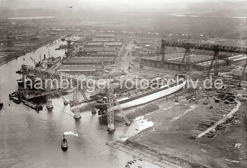 e>Luftfoto Deutsche Werft Hamburg Finkenwerder - Schiffsneubau , Stapellauf; 1932. historische Hamburgfotos Fotoleinewand mit Keilrahmen zum Geschenk zu Weihnachten, Geburtstag, Jubilaeum. 304_5_0010 Luftaufnahme der Deutschen Werft in Hamburg Finkenwerder - ein Schiffsneubau liegt auf der Helge; das umstehende Publikum wartet auf den Stapellauf, wie auch die kleinen Boote, die im Vordergrund auf dem Wasser zu erkennen sind. Lks. der Steendiek Kanal - mehrere Schiffe liegen im dortigen Ausrstungshafen.