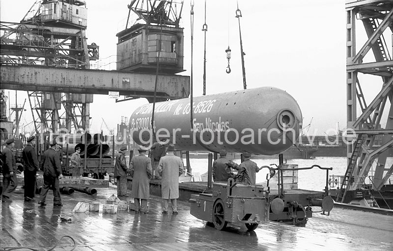 Schwergutverladung im Hafen Hamburg - Schwimmkran 1952 443_08 Der HHLA Schwimmkran nimmt einen Destillationsturm von einem Gterwaggon auf - der Bestimmungsort San Nicolas auf Aruba, einer Insel vor der Kste Venezuelas ist auf die Seite des Turms gedruckt - ebenso wie das Gewicht von 63000kg.