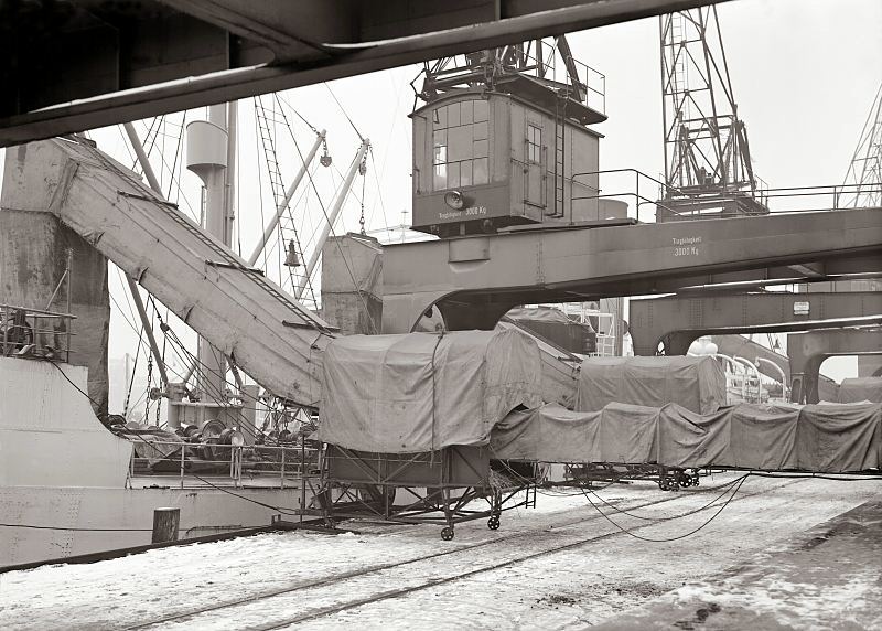 Ladung lschen im Hamburger Hafen - ein Bananendampfer wird entladen; Transportband ca. 1932. Bilder von Hamburgs Geschichte - Arbeit im Hafen Hamburgs.  476_696 Die Ladung eines Bananenfrachter wird im Hamburger Hafen gelscht. Ein geschlossenes Frderband schtz die empfindlichen Bananen vor Klte und bringt die Sdfrchte sicher in den Fruchtschuppen.
