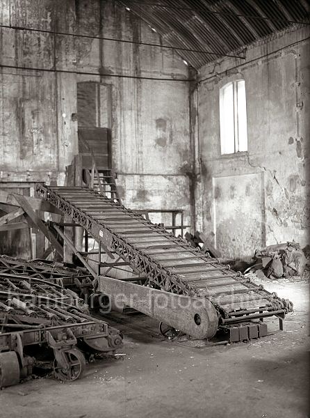 Historisches  Bildmaterial Technik - Fotoarchiv der Hamburger Hafen und Logistik AG(HHLA)- Sackstapelmaschine in einem Kaischuppen - hoch gestapelte Scke. 493_194 Mit einer Sackstapelmaschine wurde die harte Arbeit der Hafenarbeiter in den Lagerschuppen erleichtert. Mit dem Frderband werden die schweren Scke auf die oberste Lage des Stapels transportiert und von Hand verteilt.