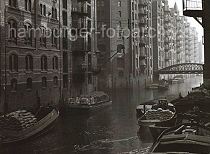 498_3502_108 Schuten haben an den Mauern der Speicherstadt im Wandrahms Fleet fest gemacht. Die Lastkhne sind mit Scken und Kisten beladen. Im Hintergrund die Eisenkonstruktion der Brcke Dienerreihe ber das Fleet.