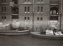 499_3502_109 Warenumschlag in der Speicherstadt - die Ladung zweier Schuten wird gelscht. Mit den Winden, die sciher unter den Dchern der Speichergebude befinden, werden die Scke auf die Bden der Lagerrume gebracht.