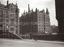 501_567 Blick vom Neuen Wandrahm zur Kannengiesserortbrcke und die Kaispeicher P (lks.) und Q (re.) Ein Pferdefuhrwerk fhrt mit Scken und Kisten hochbeladen auf der Kopfsteinpflaster-Strasse. Im Hintergrund rechts die Neuerwegsbrcke und die Fassade und der hohe Schornstein vom Kaispeicher B am Brooktorhafen.