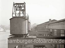 514_429 Blick ber die Halbportalkrane am Kaiserkai des Sandtorhafens. Die Rder der beweglichen Krananlage laufen auf Schienen an der Kaimauer und an der Fassade des Kaischuppens. Darunter knnen die Lastwagen und Gterzge an der Laderampe beladen werden.