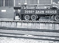 522_0003 Der Gabelstaplerfahrer hat die Fsser auf der Ladeflche des LKW-Anhngers abgeladen - zwei Arbeiter rollen die Metalltonnen auf dem Anhnger der Spedition Josef Zaun / Neuss, um sie sicher zu verstauen. Im Vordergrund Eisenbahnschienen der Hafenbahn vor der Laderampe.